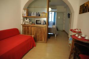 a living room with a red couch and a microwave at La Piazzetta B&B - Mini appartamento con ingresso indipendente in Isernia