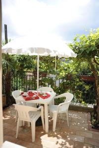a white table and chairs under an umbrella at La Piazzetta B&B - Mini appartamento con ingresso indipendente in Isernia