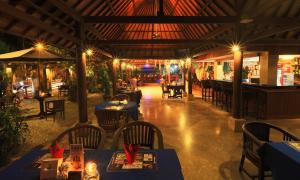 a restaurant with blue tables and chairs and a bar at Laghawa Beach Hotel in Sanur