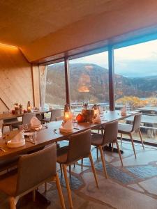 a dining room with tables and chairs and a large window at Hikers Camp, Part of Preikestolen BaseCamp in Jørpeland