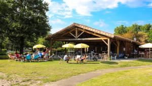 a group of people sitting in chairs in front of a building at CAMPING AZU'RIVAGE in Azur