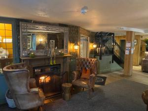 a living room with two chairs and a fireplace at The Inn At Grasmere in Grasmere