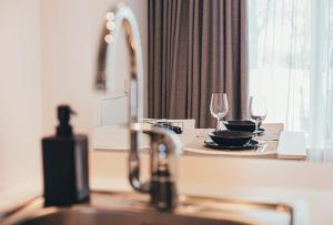 a kitchen with a sink and a table with wine glasses at Ring Stop Holiday Apartment in Sigulda