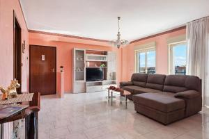 a living room with a couch and a television at Appartamento Sicilia Etna e Mare in Mascali