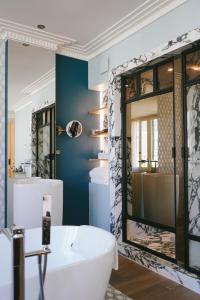 baño con bañera blanca y espejo grande en Hôtel Singulier Bordeaux en Burdeos