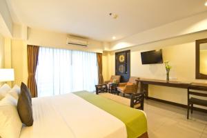 パタヤ・セントラルにあるGolden Sea Pattaya - SHA Extra Plusのベッドと机があるホテルの部屋
