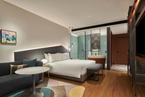 a hotel room with a bed and a couch at Artyzen Habitat Qiantan Shanghai in Shanghai +31 photos