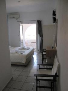 a bedroom with a bed and a table and a window at Marcos Beach in Mylopotas