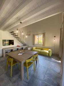 a living room with a wooden table and yellow chairs at Villetta La Cellula in Casa Alzi