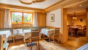 a restaurant with tables and chairs and a window at Gästehäuser Schwemmbauer in Reit im Winkl