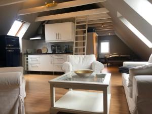 a living room with white chairs and a table at Riverview Loft in Central Herzogenaurach in Herzogenaurach