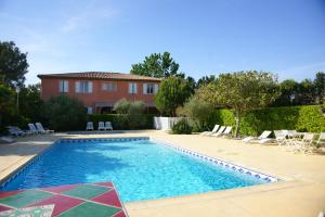 a pool with chairs and a house in the background at LOGIS HOTEL & RESTAURANT L'ETAPE Bouc Bel Air - Gardanne in Bouc-Bel-Air