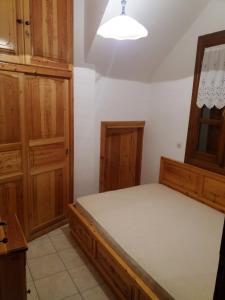 - une chambre avec un lit et des placards en bois dans l'établissement Domus, à Damouchari