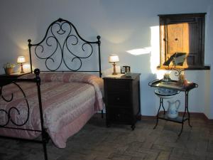 Schlafzimmer mit einem Bett, einem Tisch und einem Spiegel in der Unterkunft Casette degli Avi in Rocchette di Fazio