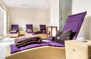 a room with purple chairs and a purple couch at Strandhotel Juister Hof in Juist