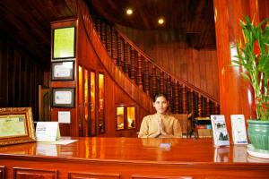 uma mulher sentada numa secretária num quarto em Shining Angkor Boutique Hotel em Siem Reap