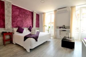 1 dormitorio con 1 cama blanca grande y paredes moradas en Hostal Alexis Madrid, en Madrid