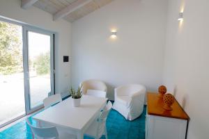 パリヌーロにあるDonnasiliaの窓付きの客室で、白いテーブルと椅子が備わります。