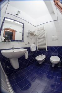 a blue tiled bathroom with a sink and a toilet at Hotel Il Tiglio in Castel di Sangro