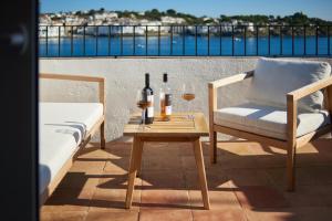 a table with wine bottles and glasses on a balcony at Beachfront Penthouse with Sea Views in CADAQUES in Cadaqués