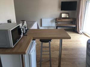 uma sala de estar com uma mesa com um micro-ondas e uma cozinha em Bond End Road Annex Upton St Leonards - Ideal for Cheltenham Races em Matson