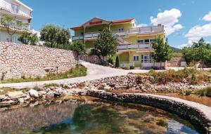 a house with a pond in front of a building at Nice Apartment In Ribnica-krusevo With 1 Bedrooms And Wifi in Anić