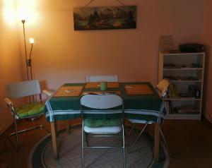 a dining room table with chairs and a green tablecloth at Waldblick in Herl