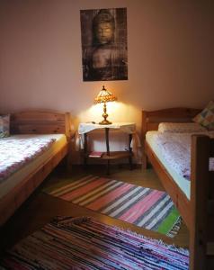 a room with two beds and a table with a lamp at Waldblick in Herl