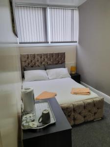 a bedroom with a bed and a table with a tray at NIRO's Hotel in Blackpool
