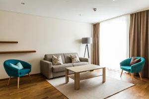 ein Wohnzimmer mit einem Sofa und 2 Stühlen in der Unterkunft Restaurant Hotel Zum Storchen in Waldkirch