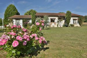a house with pink roses in the yard at L'Ariade in Monpazier