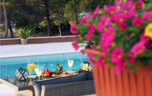 een tafel met glazen wijn en bloemen naast een zwembad bij Nice Home In Supetar With Private Swimming Pool, Can Be Inside Or Outside in Supetar