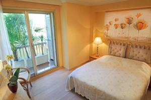 1 dormitorio con cama y ventana grande en 90m2 Apartement - Les Palmiers de Cannes, en Cannes
