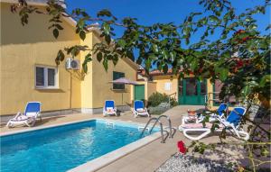 a swimming pool with chairs next to a building at 3 Bedroom Gorgeous Home In Labin in Labin