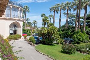 uma entrada em frente a uma casa com palmeiras em 90m2 Apartement - Les Palmiers de Cannes em Cannes