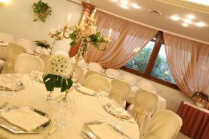 a dining room with a table with white chairs and a table set up at Hotel Mazzoleni in Roncola