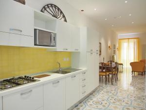 a kitchen with a stove a sink and a microwave at Residence Degli Agrumi in Taormina