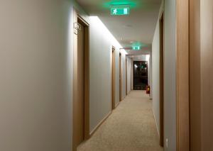 a hallway with a row of doors with green lights at Kriti Hotel in Chania Town