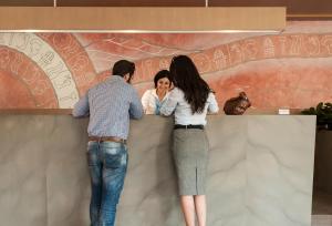 a group of three people looking over a wall at Kriti Hotel in Chania Town