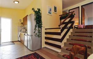 a kitchen with a refrigerator and stairs in a room at Nice Home In Podgradina With 6 Bedrooms, Wifi And Outdoor Swimming Pool in Posedarje