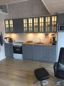 
a kitchen with a wooden floor and wooden cabinets at Mersted Holiday House in Tønder
