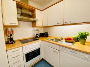 una cocina con armarios blancos y fregadero en Seeschloss "Meerblick", en Bansin