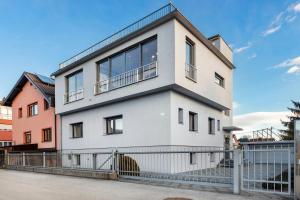 una casa blanca con una valla delante en Contemporary apartment with rooftop terrace in Maribor en Maribor