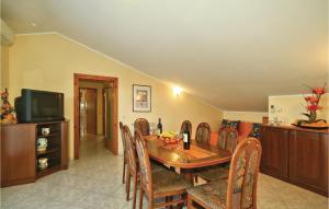 a dining room with a wooden table and chairs at Beautiful Apartment In Porec With 3 Bedrooms And Wifi in Poreč