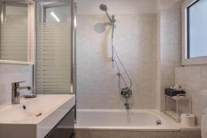 ボルツァーノにあるAppartamento a Villa Osvaldaのシャワー、浴槽、洗面台を備えたバスルーム