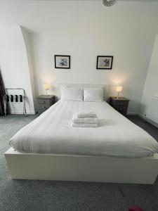 a bedroom with a white bed with two night stands at Runnacleave Court in Ilfracombe