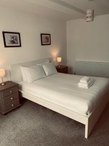 a bedroom with a large white bed with two night stands at Runnacleave Court in Ilfracombe