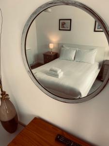 a bedroom with a bed with a mirror on the wall at Runnacleave Court in Ilfracombe
