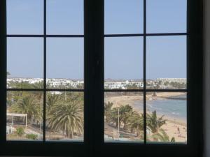 a view of a beach from a window at RealRent Costa Teguise Beach in Costa Teguise