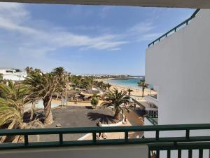 a view of the beach from the balcony of a resort at RealRent Costa Teguise Beach in Costa Teguise